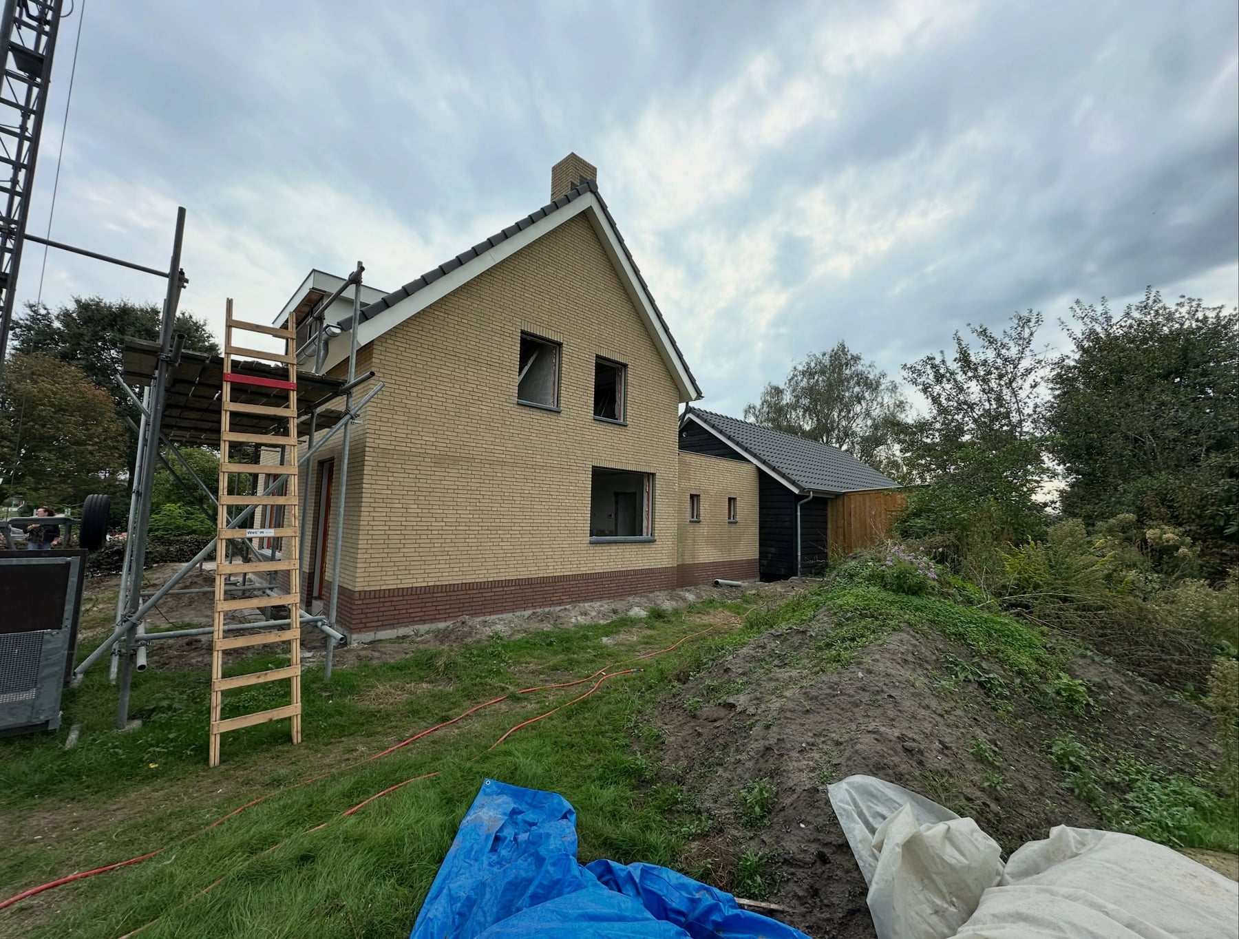 Nieuwbouwwoning in Uden in gele steen, met de ladder nog tegen de gevel